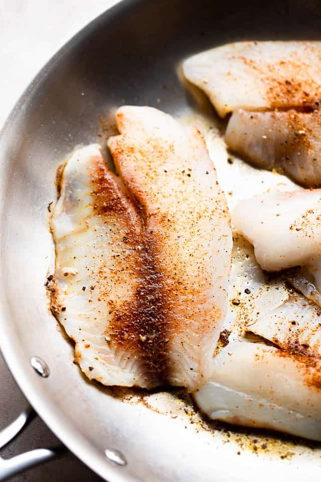 cooking tilapia fillets in a skillet