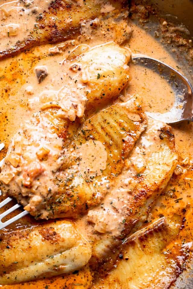 overhead shot of tilapia fillet in a cream sauce