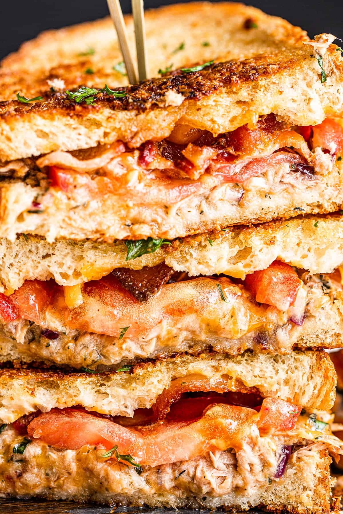 up close side shot of halved tuna cheese sandwiches and stacked up one on top of the other