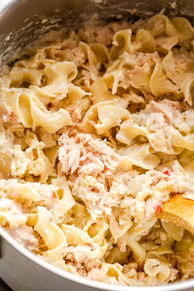 a pot filled with cooked egg noodles mixed with canned tuna