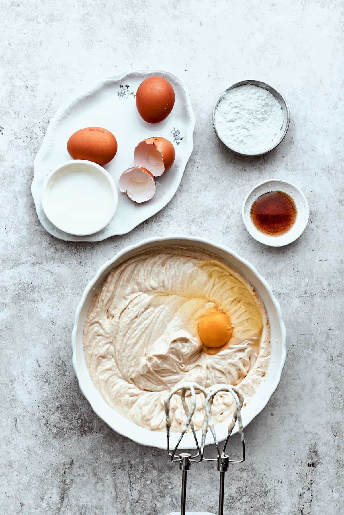 Eggs are mixed into a bowl of turtle cheesecake batter.