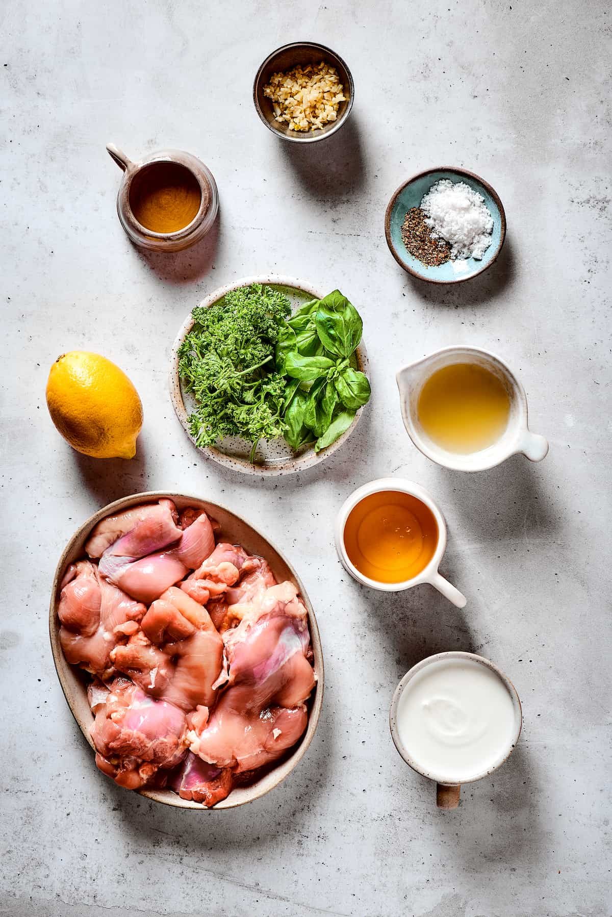 From top: Garlic, salt and pepper, lemon juice, honey, yogurt, chicken thighs, herbs, olive oil.