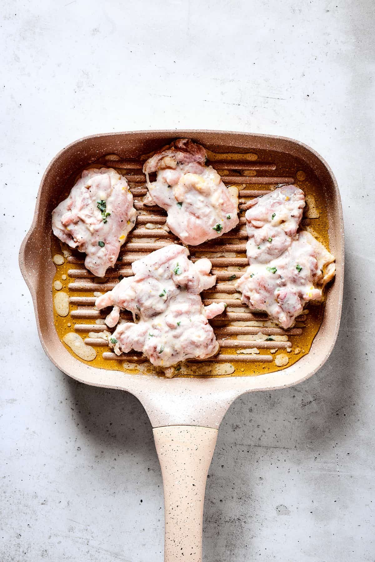Grilling chicken thighs on a grill pan.