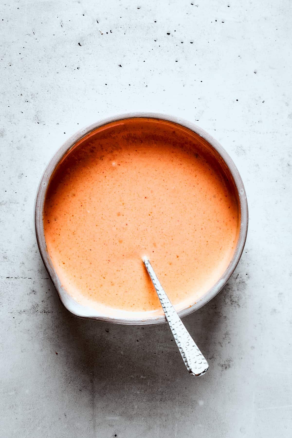Mixing the yum yum sauce with a spoon.