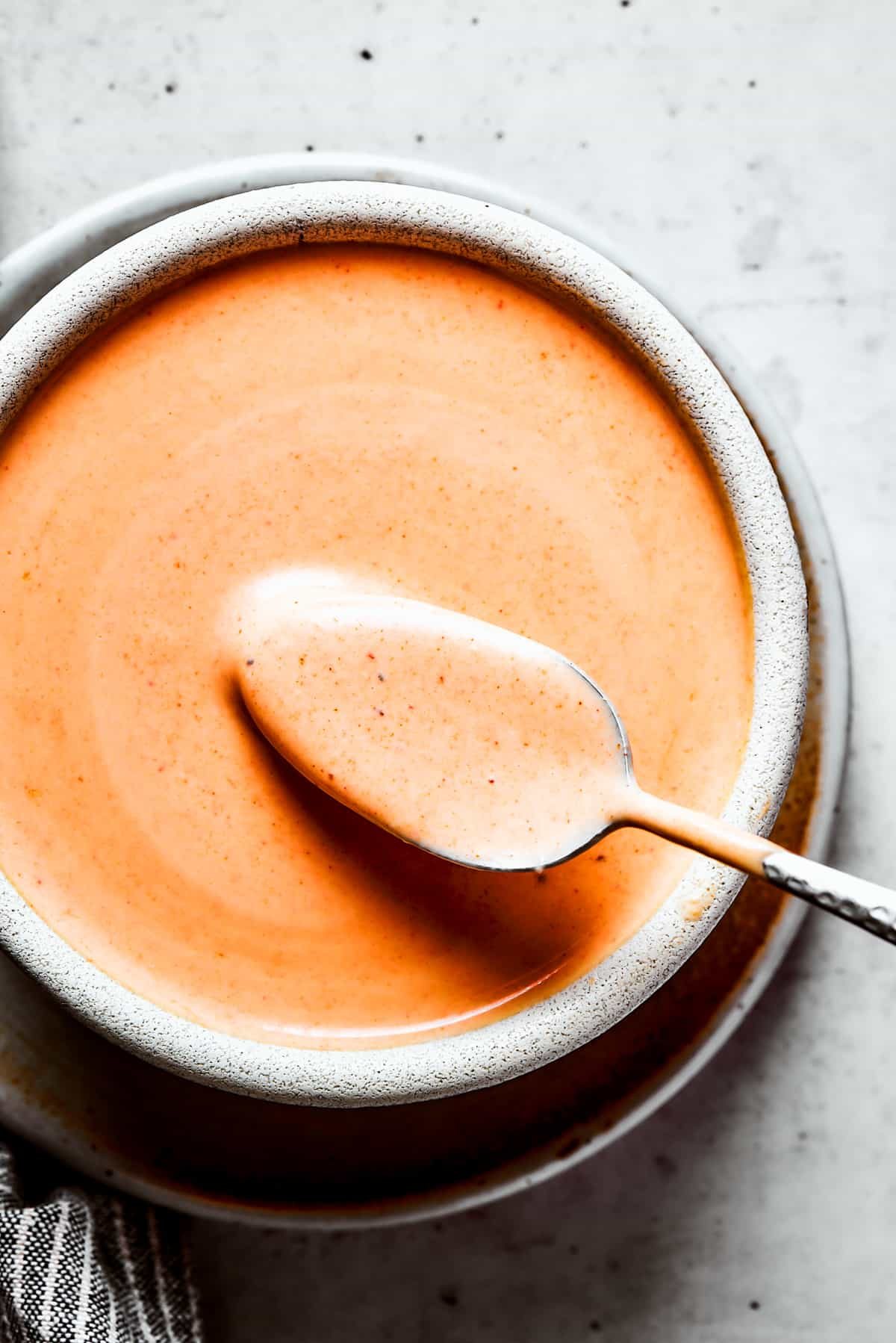 Photo of homemade yum yum sauce in a bowl, with a spoon inside.