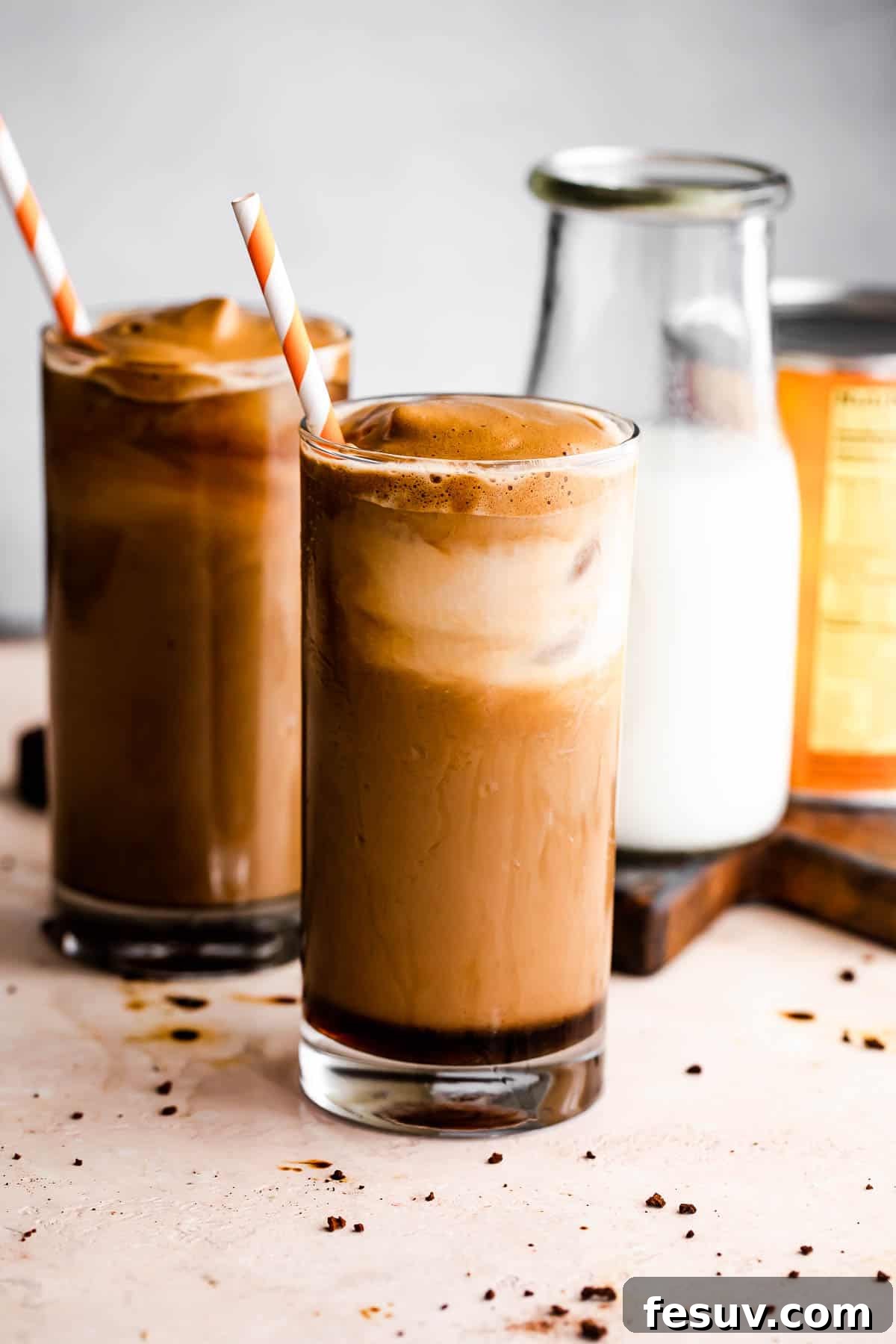 Starbucks Inspired Pumpkin Cream Cold Brew 2 Two glasses of Pumpkin Cream Cold Brew, with a milk bottle and decorative pumpkins beside them.