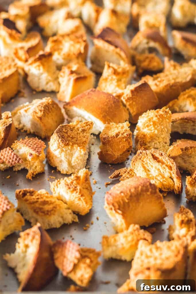 Toasted cubed French bread on a sheet pan.