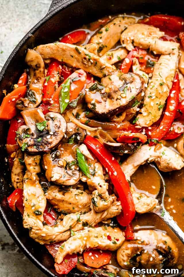 This better than takeout chicken stir fry recipe is packed full of fresh veggies and covered in a flavor-packed garlic and ginger sauce. Close-up of skillet filled with vibrant chicken stir fry, ready to be served