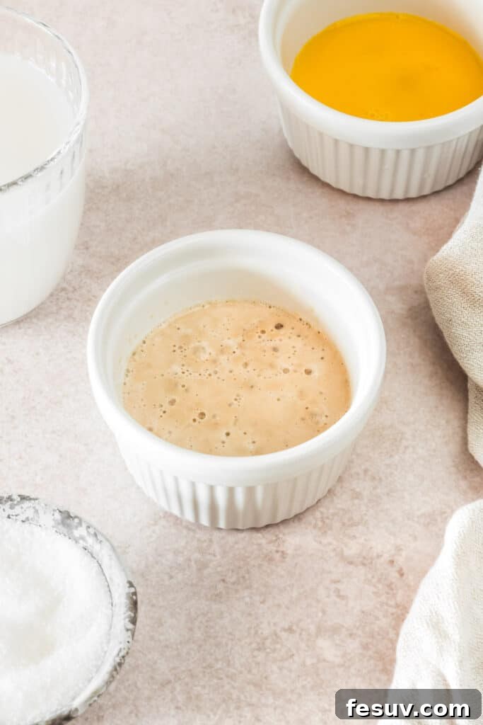 Buttery Homemade Crescent Rolls 4 Yeast and warm water, bubbling gently in a small ramekin, indicating active yeast.