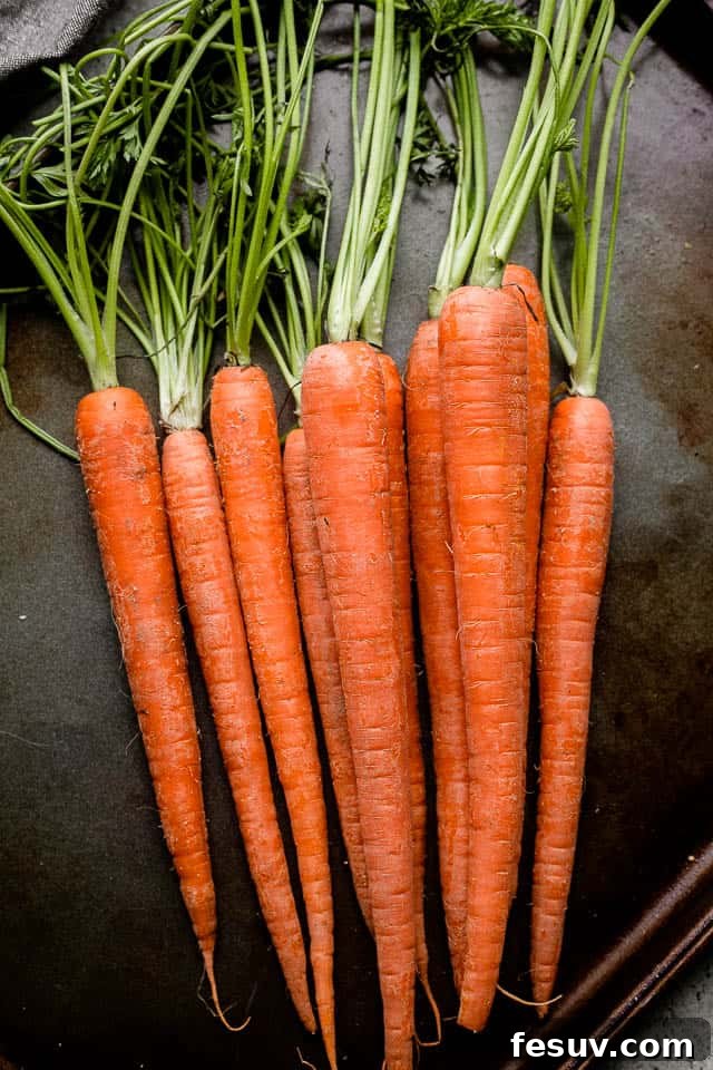 Preparation is key for perfectly roasted carrots. Raw carrots, washed and ready for peeling and cutting.