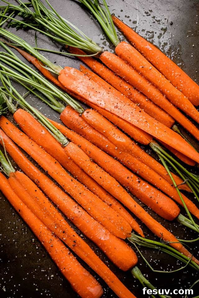 Uniformly cut carrots ensure even cooking and caramelization. Fresh carrots neatly cut in half lengthwise on a cutting board, ready for the glaze.