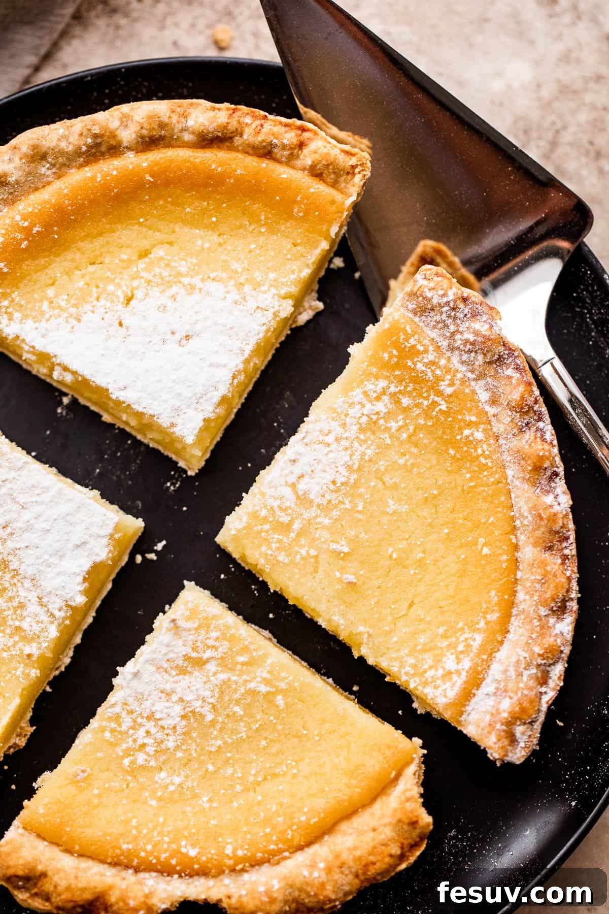 overhead shot of buttermilk pie cut into 4 slices and dusted with powdered sugar.