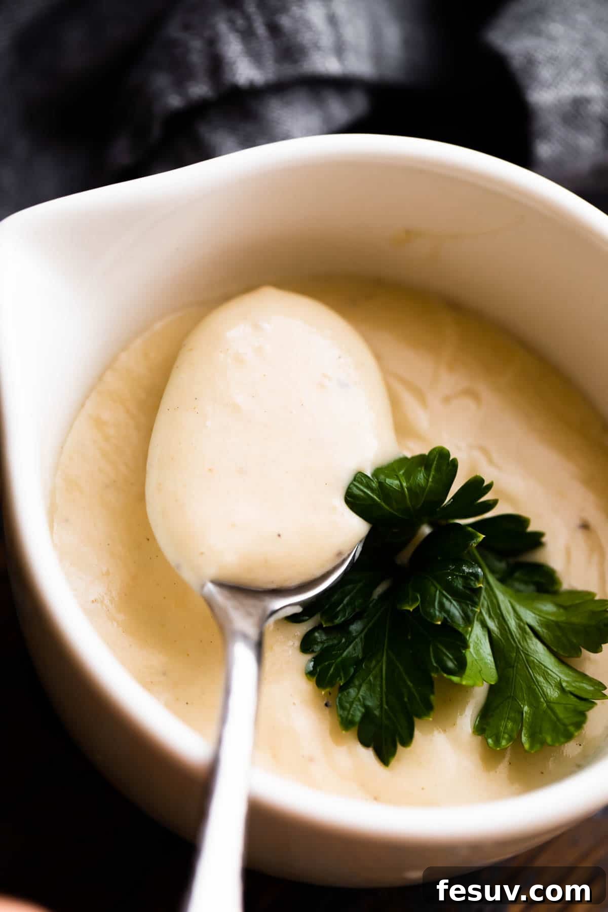 overhead shot of a white ceramic cup filled with homemade cream of chicken soup