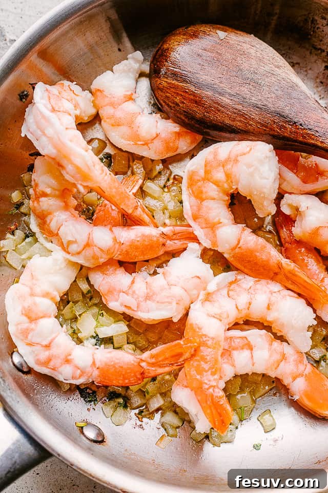 Velvet Shrimp Alfredo 2 Shrimp sauteing in a pan with garlic.