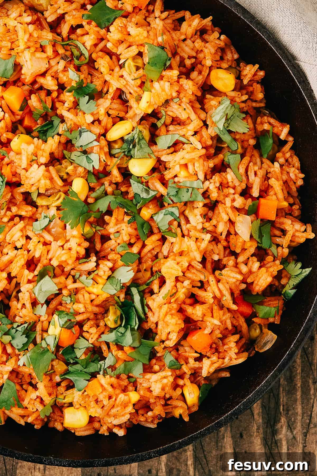 Close-up shot of a pan of seasoned Instant Pot Mexican rice and vegetables, garnished with vibrant fresh cilantro leaves.