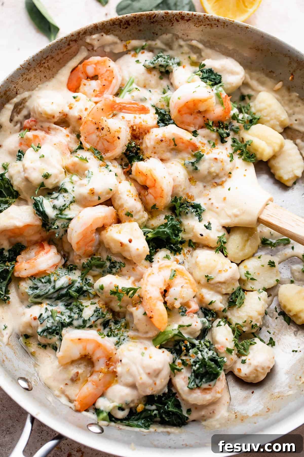 Velvet Parmesan Gnocchi with Succulent Shrimp 2 overhead shot of a steel skillet filled with gnocchi, shrimp, and greens.