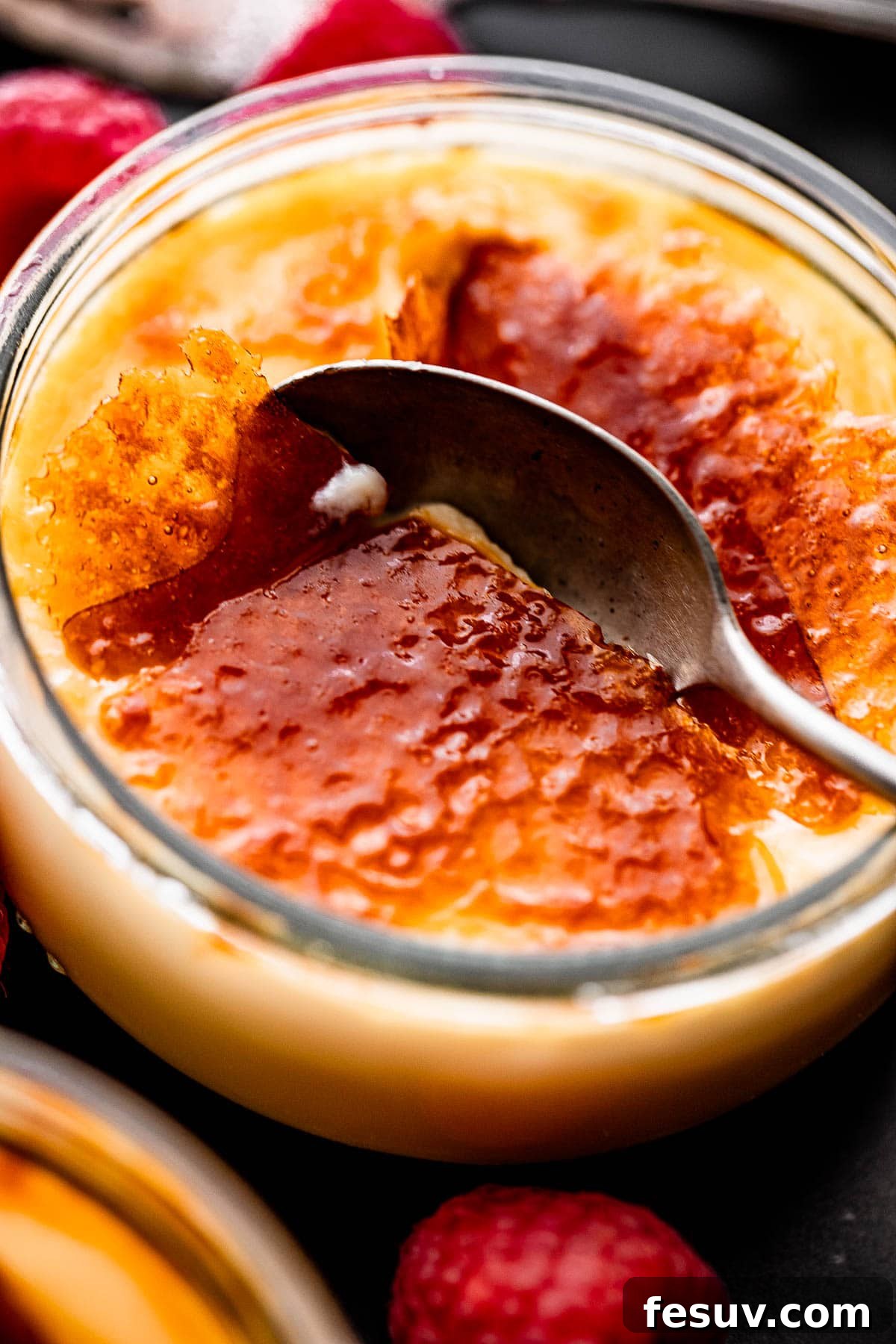 Foolproof Creme Brulee 5 close up side shot of a spoon breaking into the burnt sugar top of creme brulee.