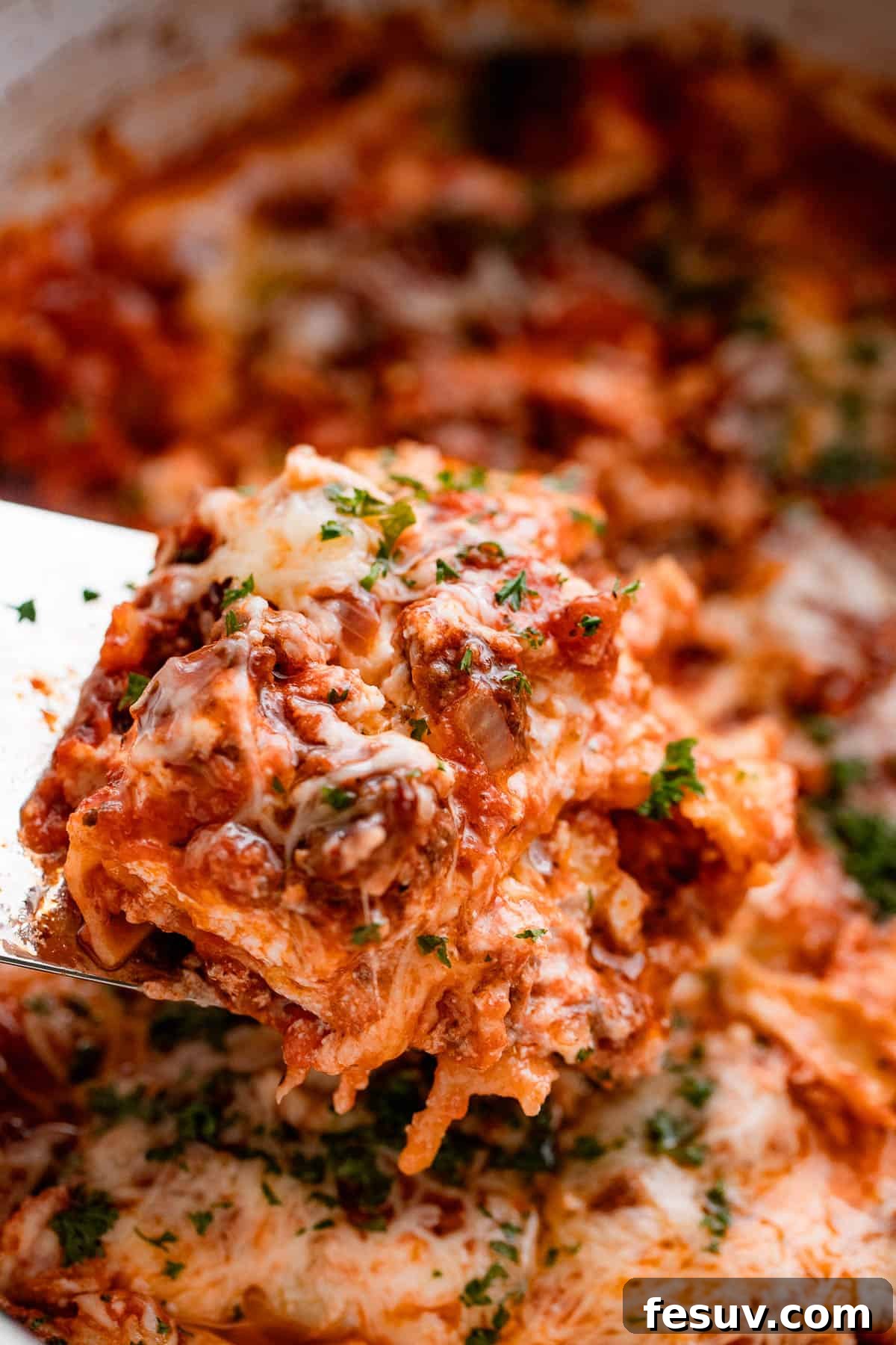 Low and Slow Lasagna Feast 2 lifting up a piece of lasagna from the slow cooker.
