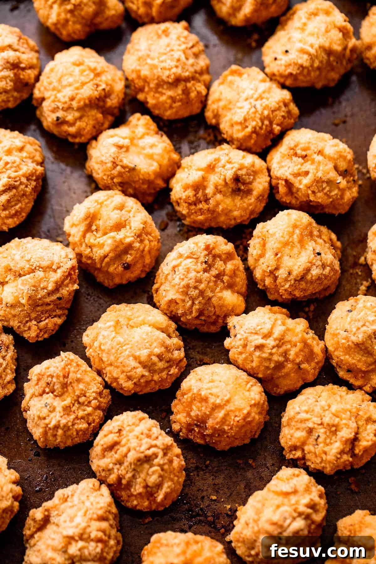 popcorn chicken arranged on a sheet pan