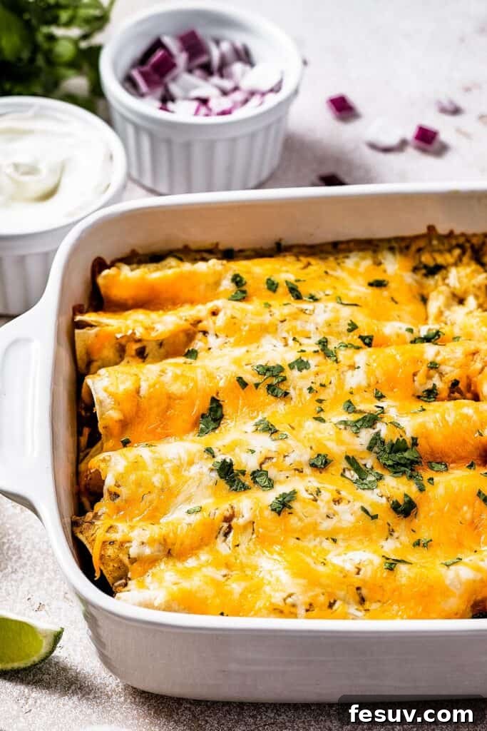 Smothered Green Chili Chicken Enchiladas 8 A beautifully baked dish of cheesy chicken enchiladas, golden and bubbling, served alongside small ceramic dishes of creamy sour cream and vibrant chopped red onion, ready for garnishing.