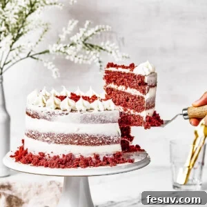 A woman's hand is lifting a slice of cake on a serving utensil.