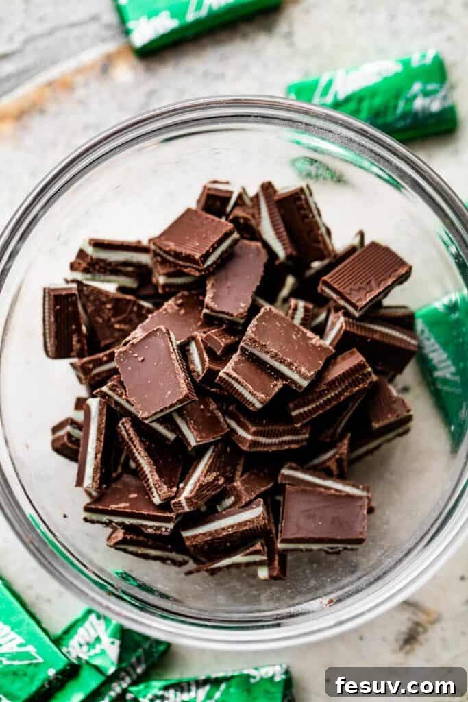 A small glass bowl filled with perfectly chopped thin creme de menthe chocolate mints, ready to be folded into cookie dough.