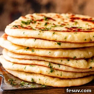 Stack of homemade flatbread on a wooden board.