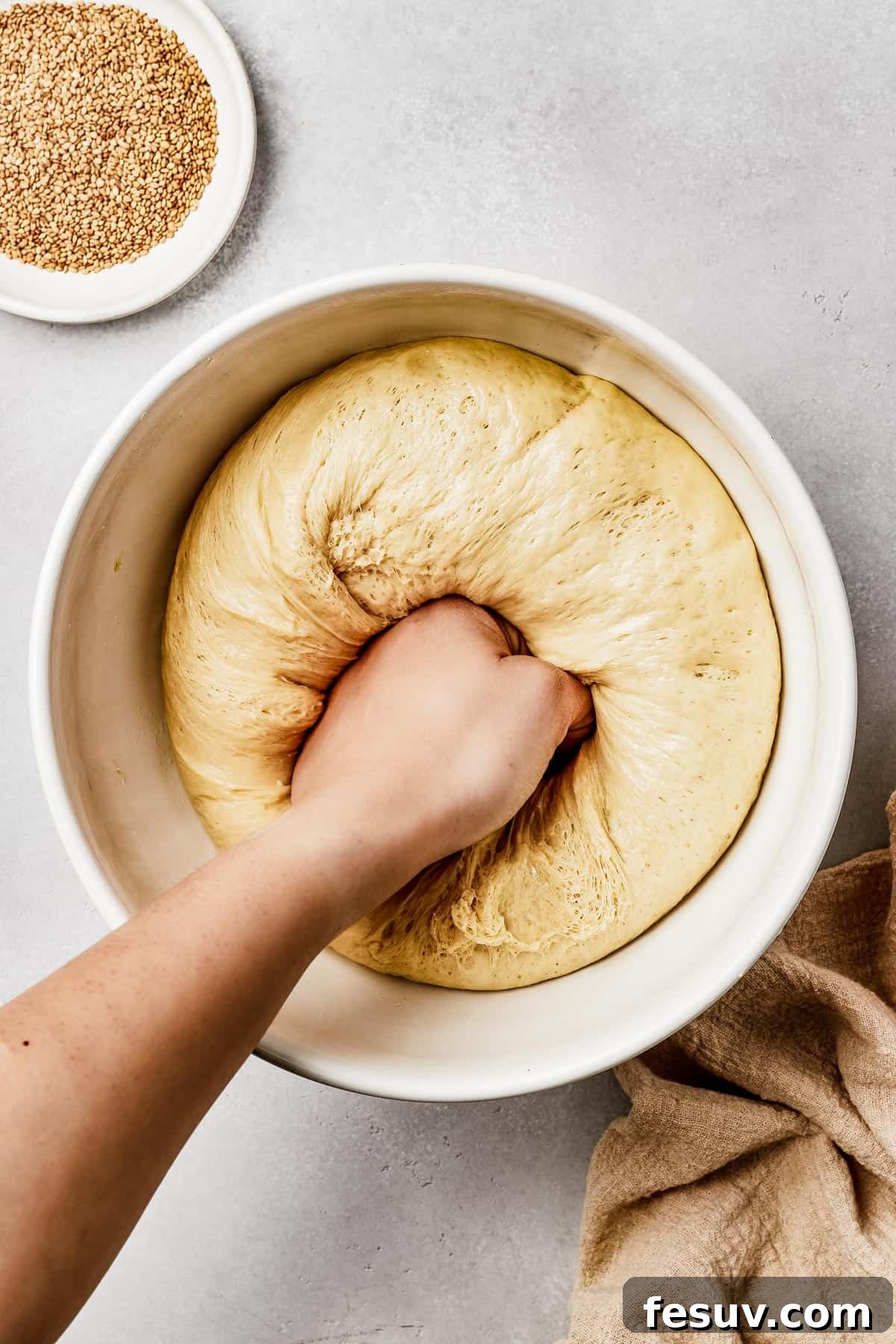 Golden Braids of Challah Perfection 6 A close-up shot of perfectly risen bread dough being gently punched down in the center, ready for the next stage of baking.