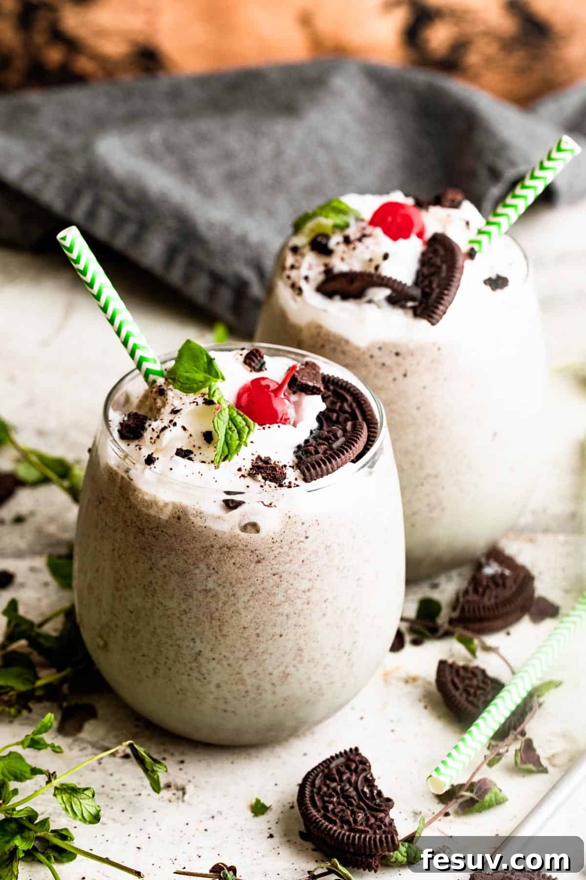 A close-up of a Shamrock Oreo McFlurry in a glass, with a focus on the creamy green texture and visible Oreo chunks, topped with whipped cream and a cherry, emphasizing its deliciousness.