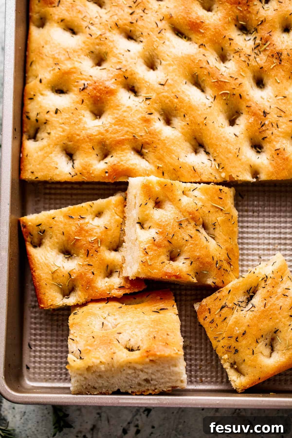 Pillowy Herb-Kissed Garlic Focaccia 8 An inviting overhead shot of freshly baked focaccia, golden and fragrant, adorned with garlic and herbs, ready to be enjoyed.