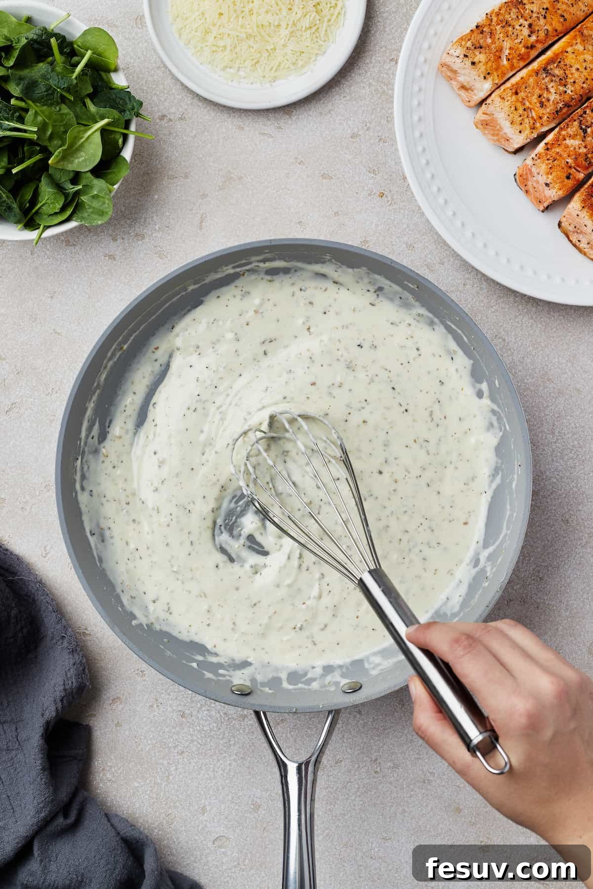 Creamy sauce being whisked in a skillet, ensuring a smooth consistency.