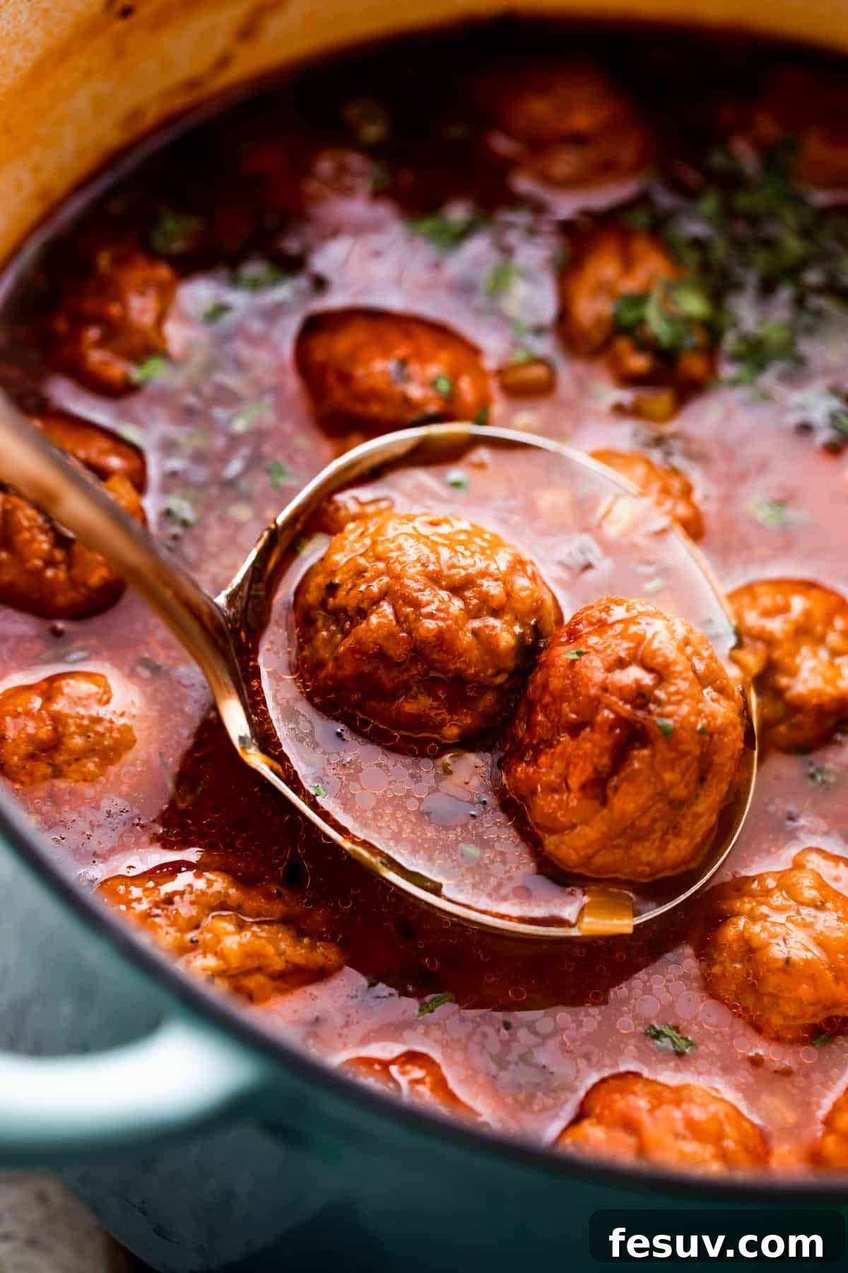 Hearty Mexican Meatball Soup 5 ladle spooning out Albondigas Soup from dutch oven.
