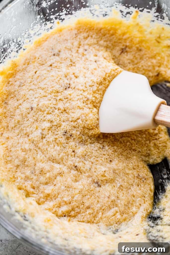 Golden Banana Chocolate Chip Cookies 4 rubber spatula stirring through liquid batter for banana cookies.