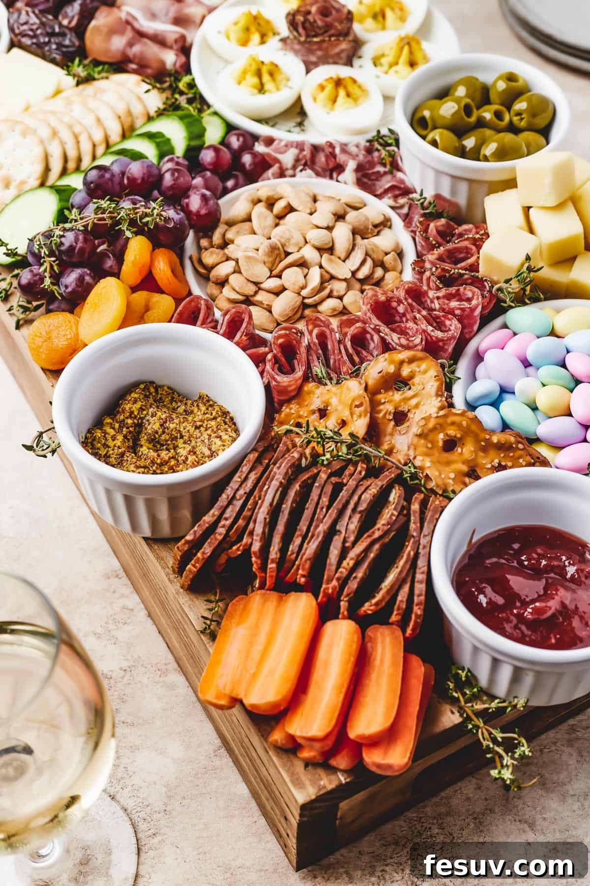 Craft the Perfect Easter Charcuterie Board 3 A close-up view of an Easter charcuterie board, highlighting a delicious combination of Marcona almonds, juicy grapes, sweet dried apricots, crisp baby carrots, and artisanal fig crackers, ready for tasting.