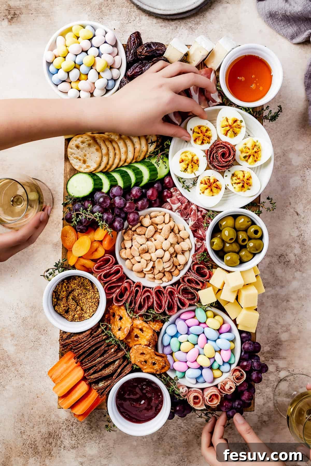 Craft the Perfect Easter Charcuterie Board 9 A lavish wooden cutting board impeccably arranged with a delightful assortment of cured meats, gourmet cheeses, crispy crackers, succulent olives, vibrant fruits, and fresh vegetables, creating an enticing display for any gathering.