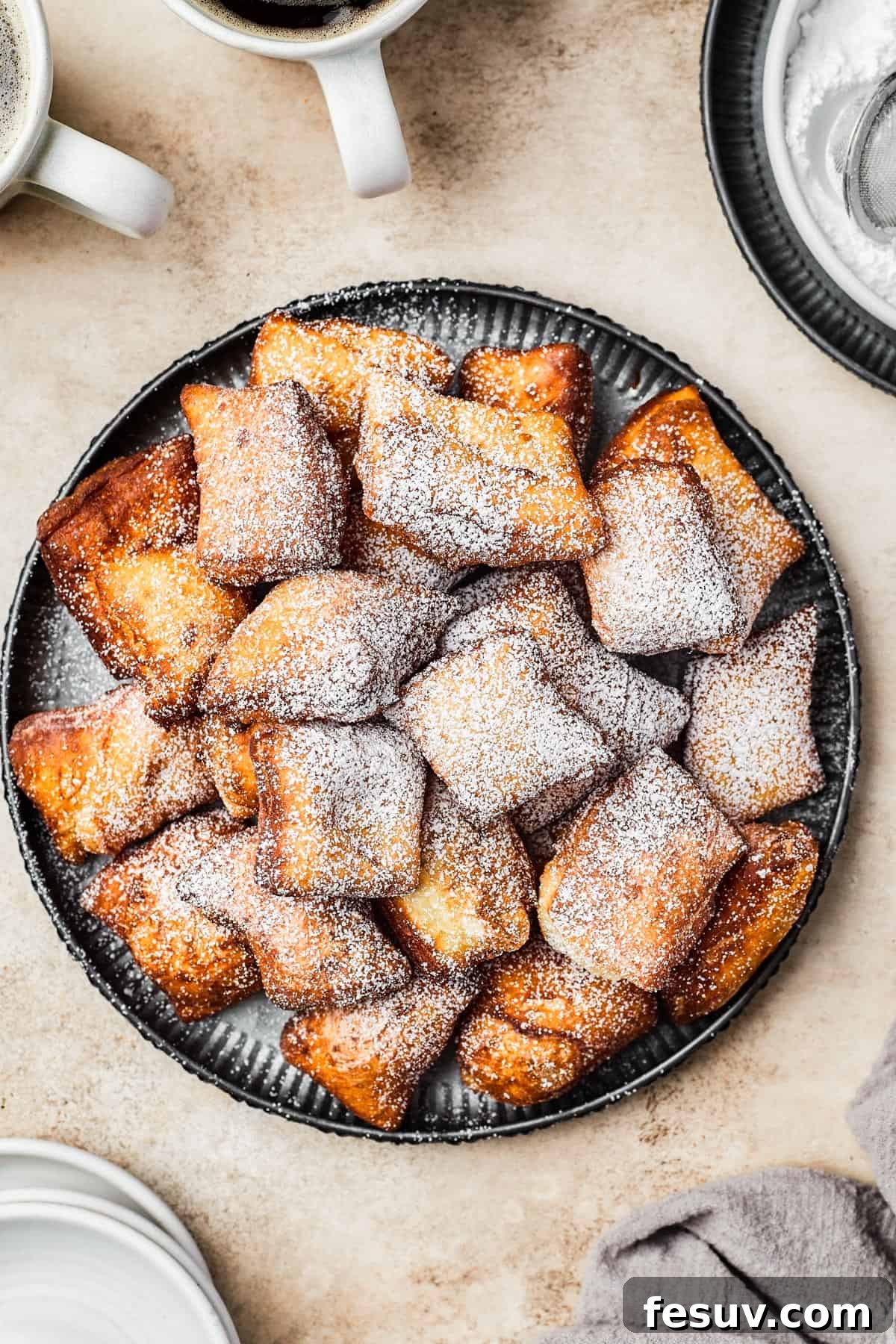 French Quarter Powdery Delights 9 A plate of fried beignets, dusted with powdered sugar.