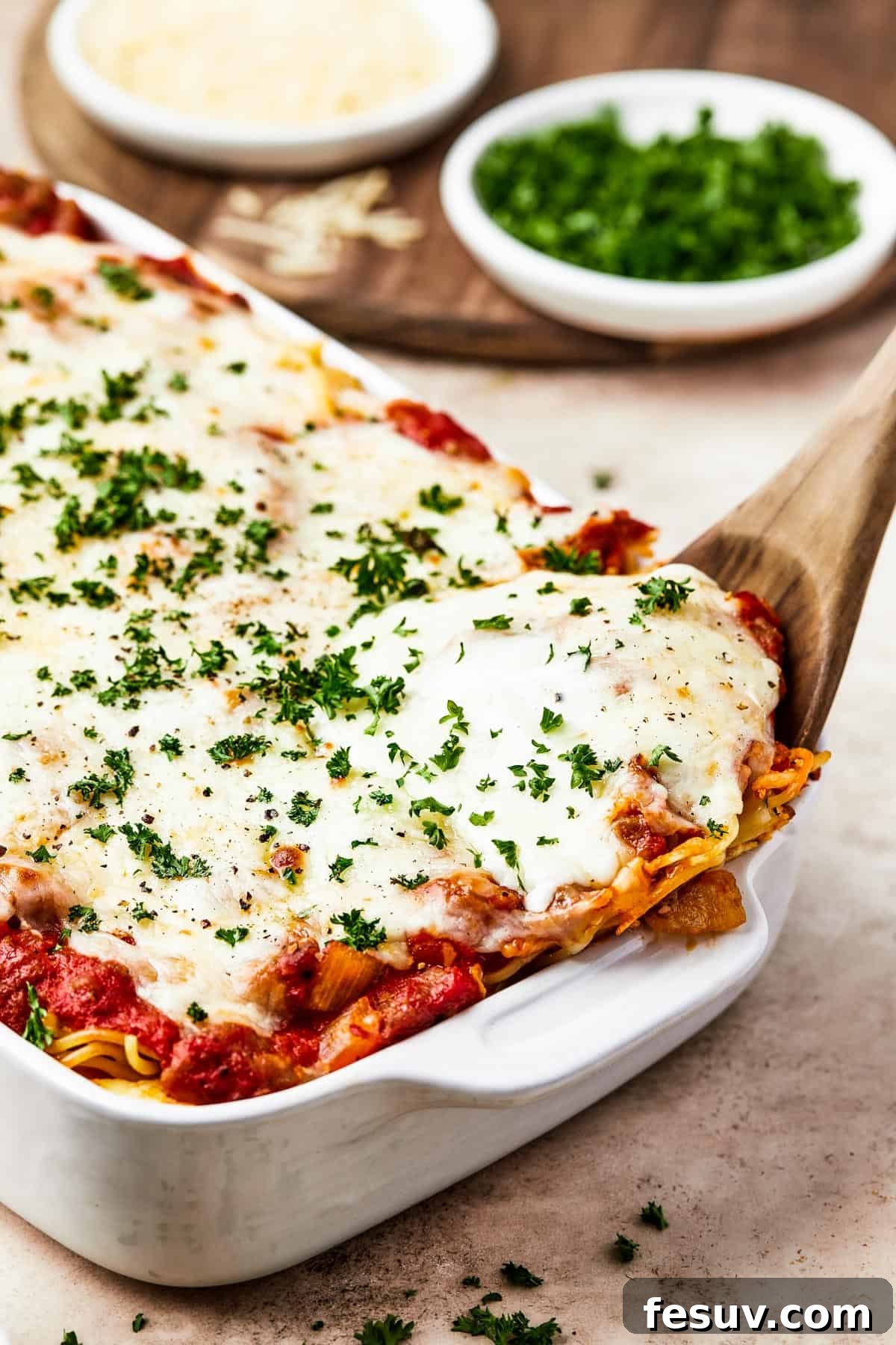Irresistible Baked Spaghetti Delight 10 A large white baking dish filled with a golden, bubbling baked spaghetti casserole, ready to be served.