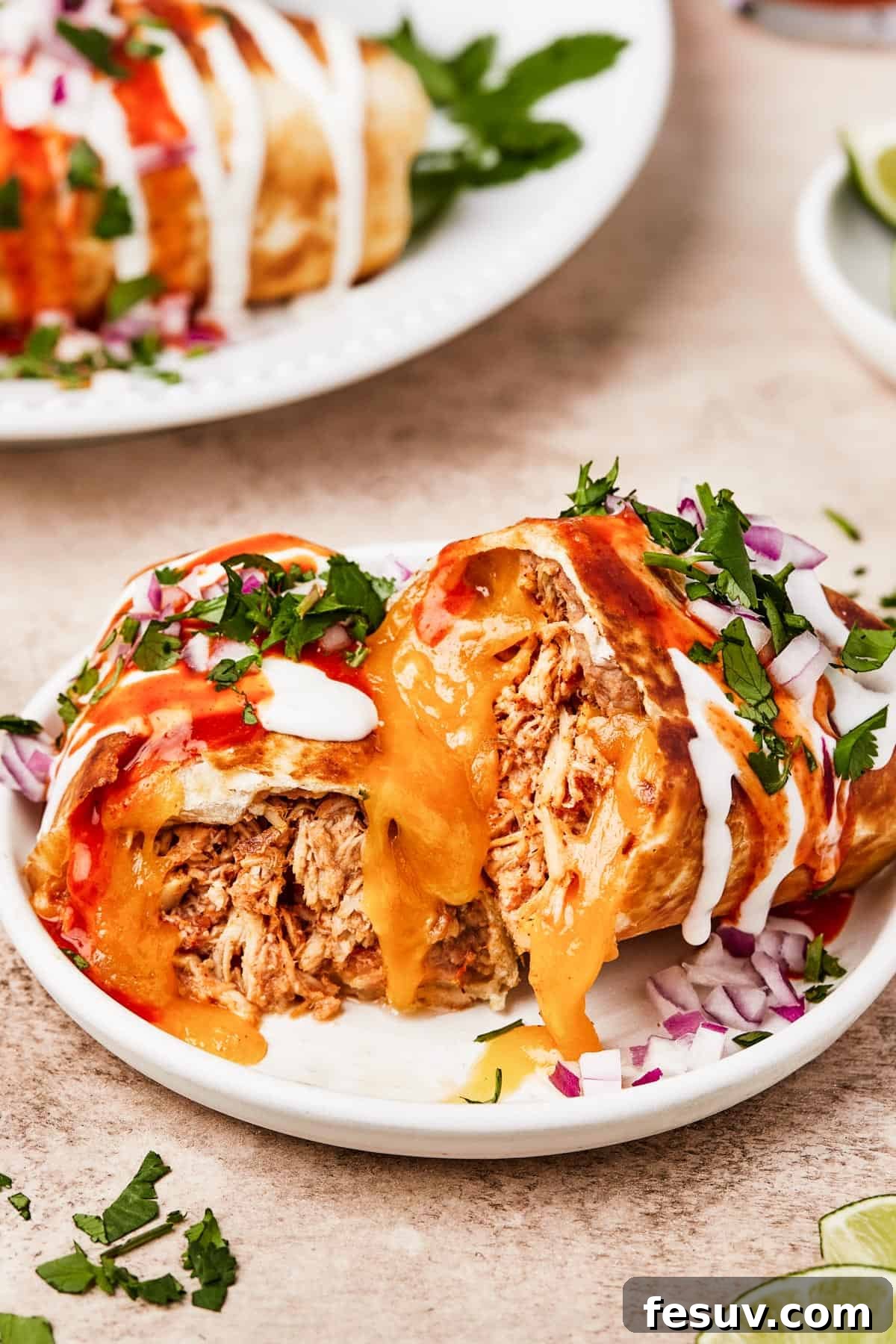 A plate with a chimichanga cut in half to show the filling.