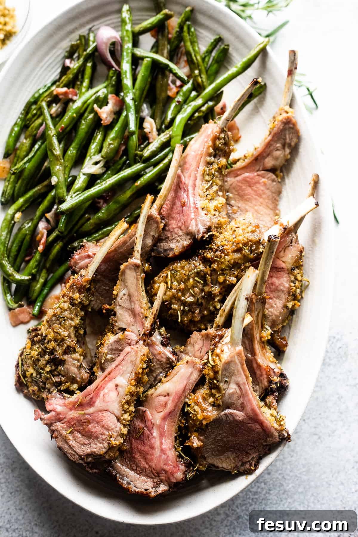Elegant Herb-Crusted Lamb Rack 2 Overhead shot of perfectly cooked, breadcrumb-coated lamb chops arranged on a serving platter, accompanied by a vibrant side of green beans.