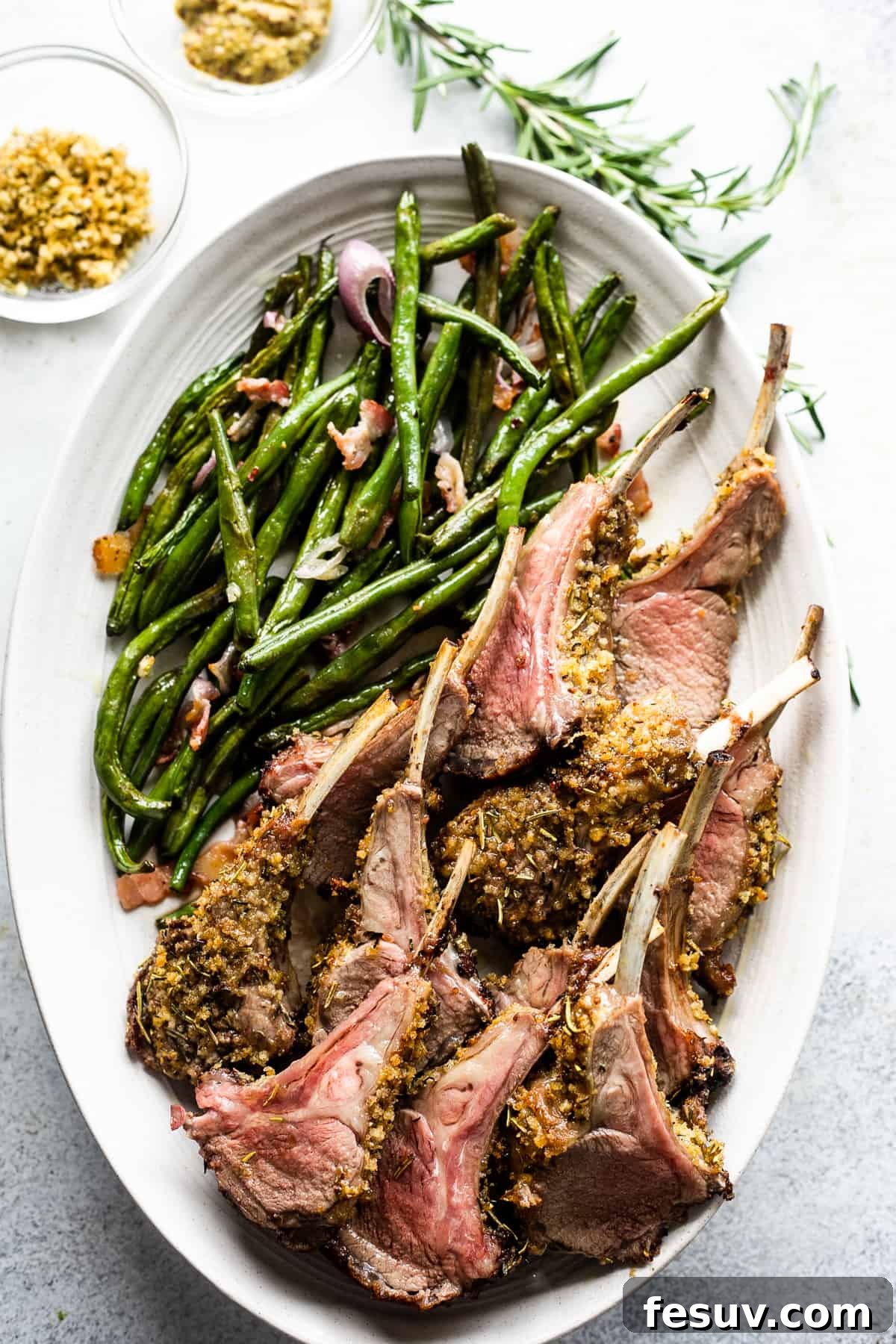 Elegant Herb-Crusted Lamb Rack 5 Overhead perspective of beautifully plated lamb chops, arranged on a serving platter with a generous portion of green beans.