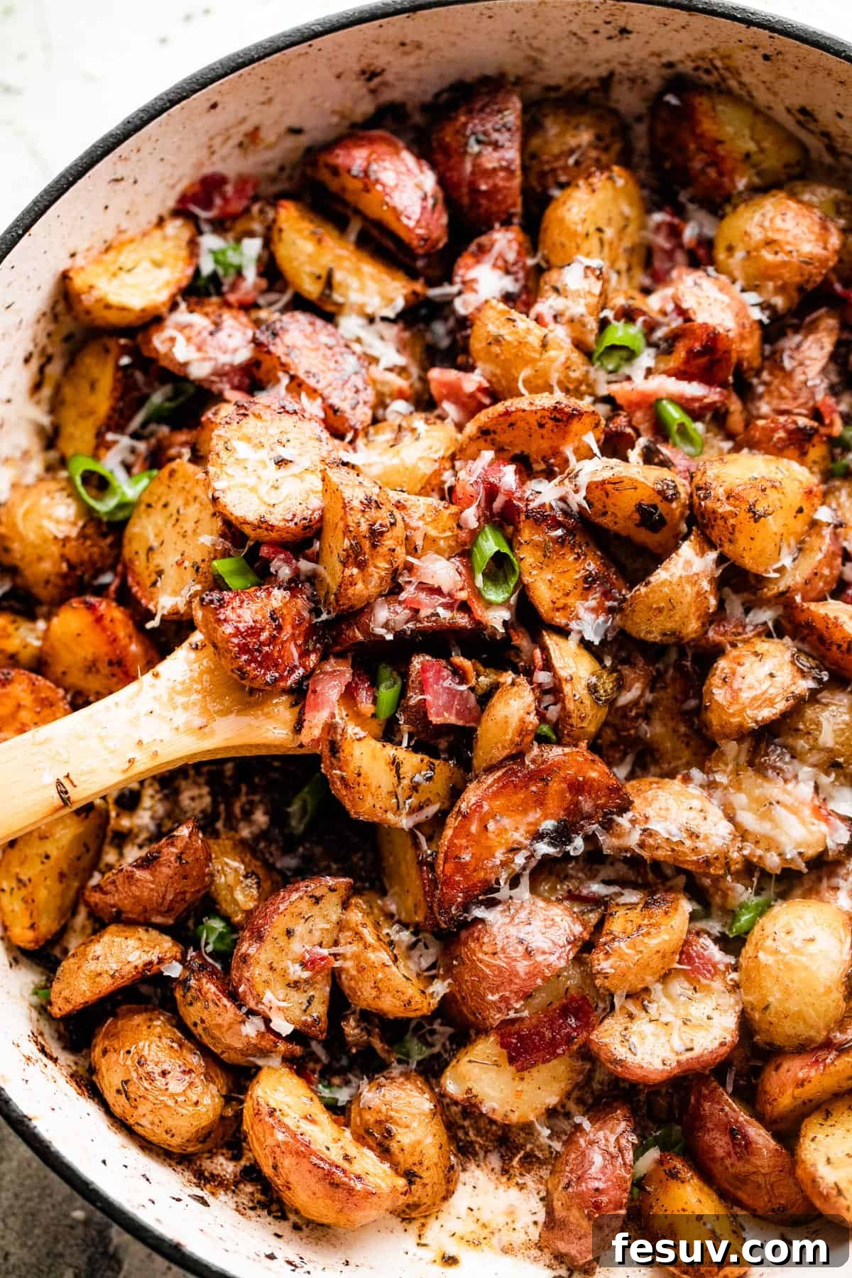 Golden Roasted Potatoes with Bacon and Cheese 2 overhead shot of roasted potatoes and bacon in a white skillet.
