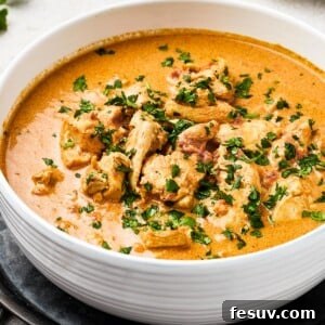 Chicken curry in a white enamel bowl.