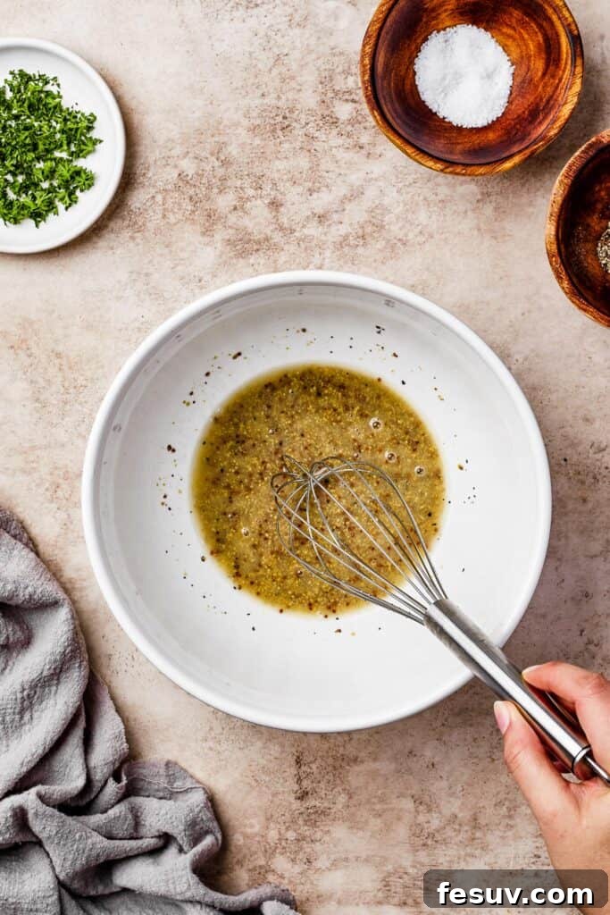 Vinaigrette ingredients being whisked in a bowl.