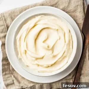 A bowl of creamy white icing on a linen napkin.
