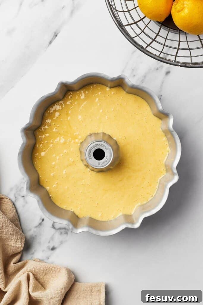 Zesty Lemon Bundt Delight 6 A Bundt pan filled with yellow batter.