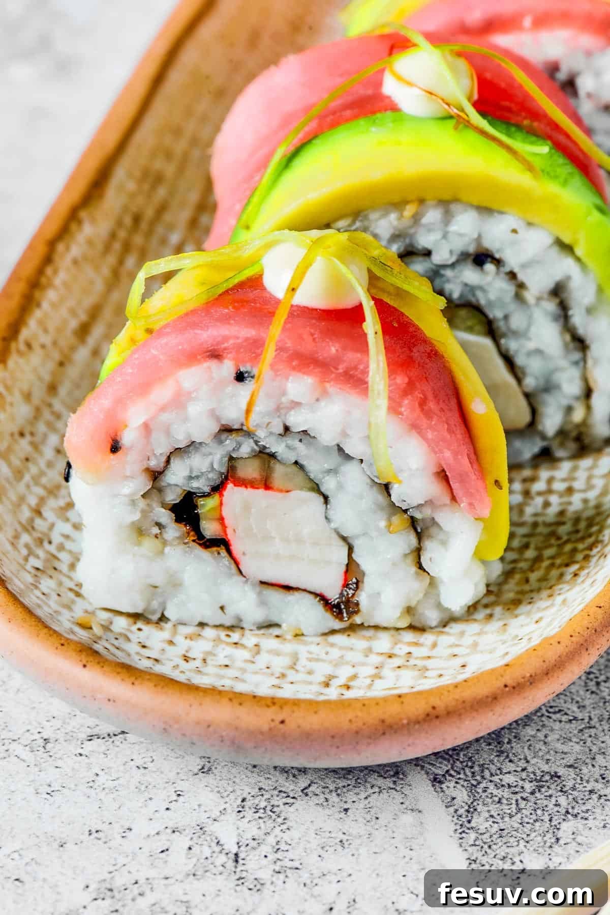 Rainbow Sushi Masterpiece 5 Close-up shot of sushi topped with salmon, avocado, mayonnaise, and pickled ginger.