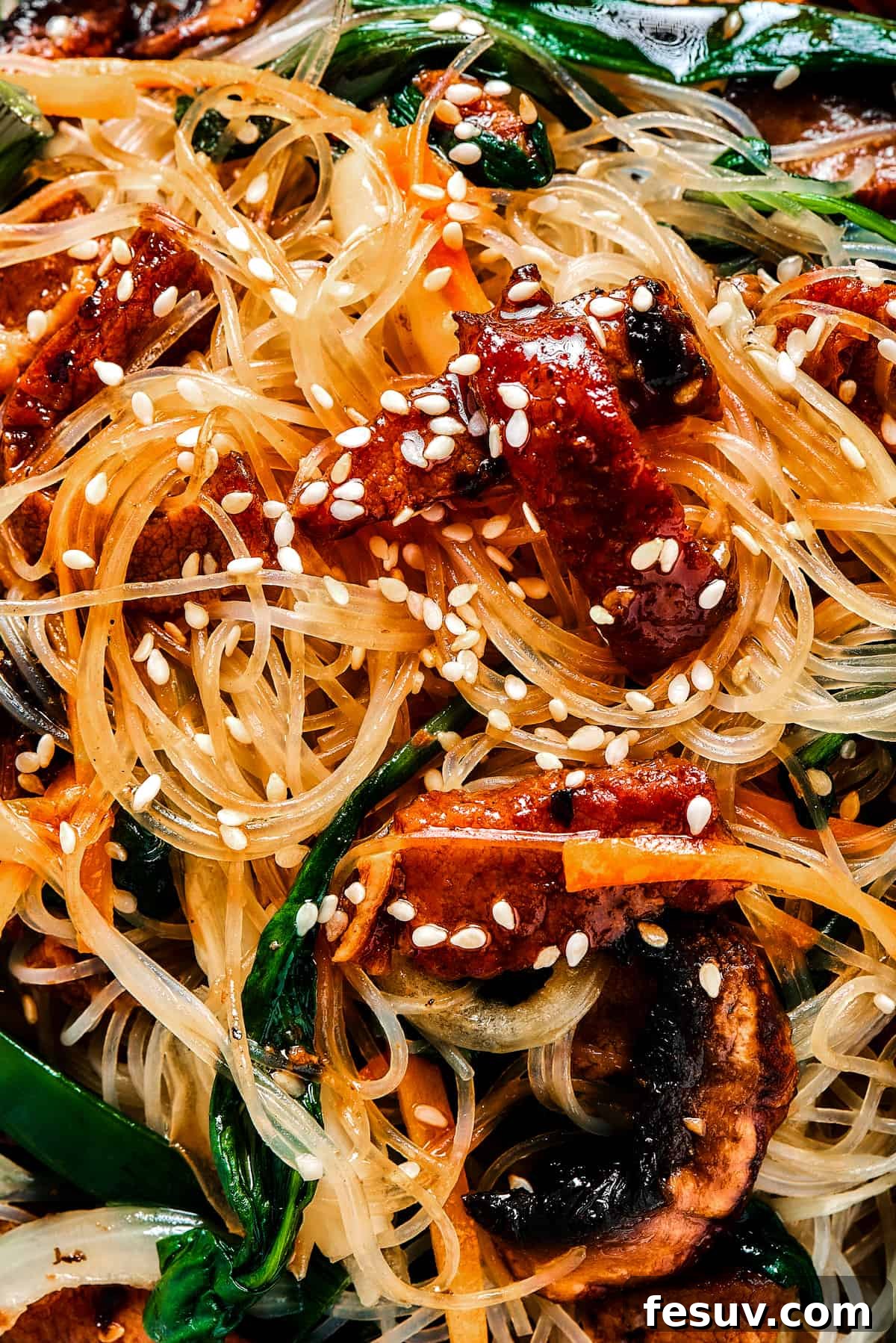close up shot of Japchae garnished with sesame seeds.