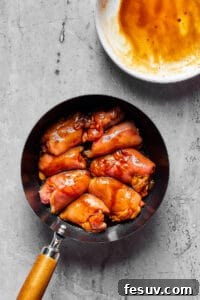Velvety Peanut Butter Chicken 5 Chicken thighs cooking in a skillet.