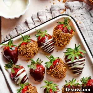 A white tray with a black border, displaying three kinds of chocolate dipped strawberries: plain, white chocolate drizzle, and toasted hazelnuts.