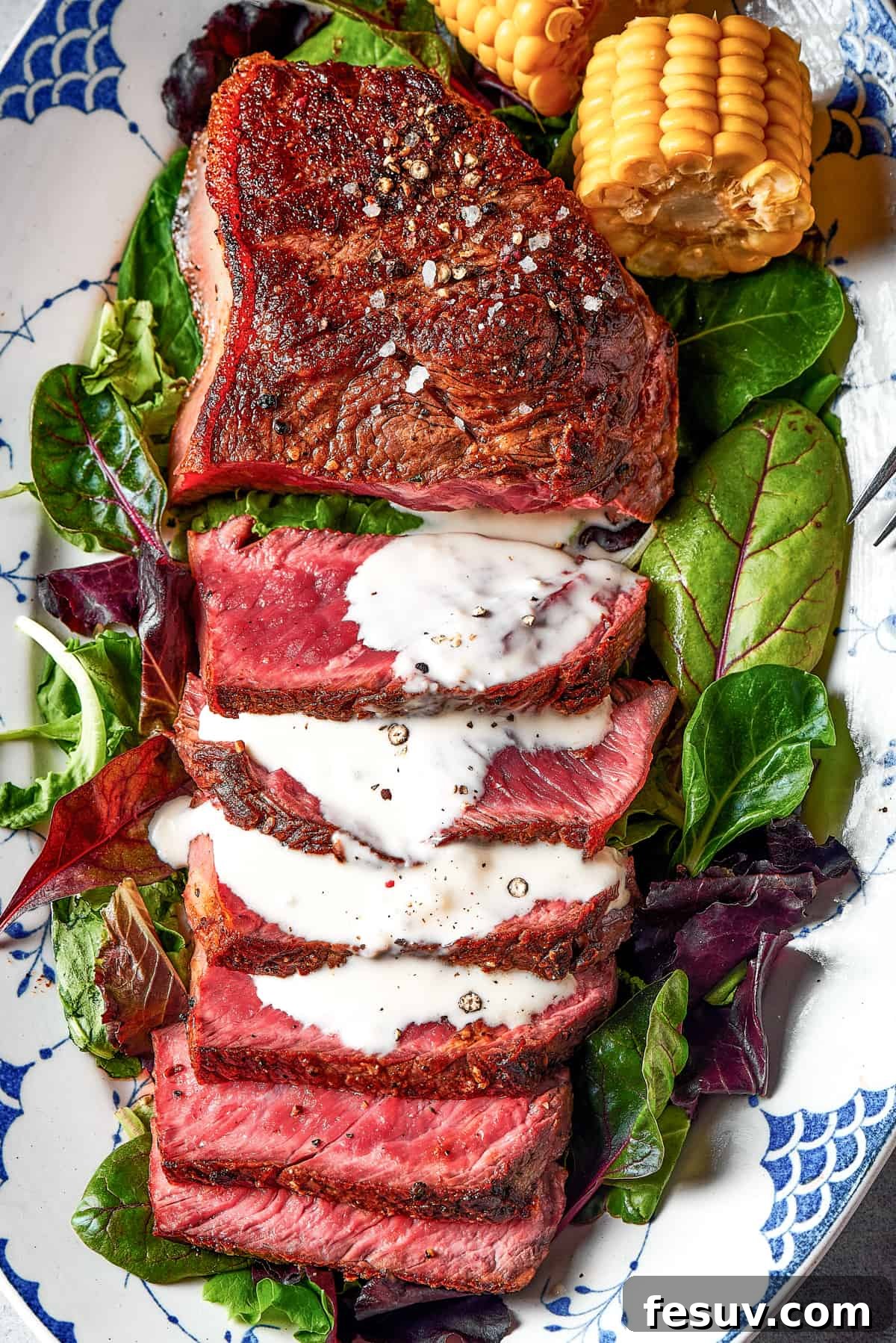 Sliced sirloin blue steak, revealing its incredibly rare, purplish-red interior, accompanied by a decadent blue cheese sauce.